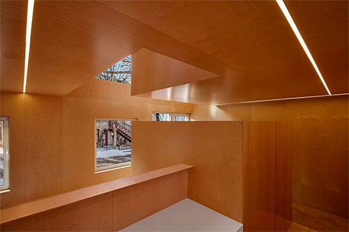 Ce cottage étonne par des agencements de volumes intérieurs uniformément parés de bois.  Photo : Maxime Brouillet