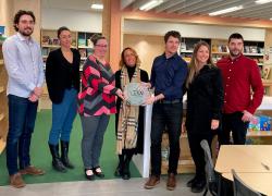 Alexandre Bouchard, ingénieur MRAS et Virginie Hallahan-Pilotte, directrice de l’école des Jolis-Prés, dévoilent la plaque attestant de la certification LEED en compagnie de membres de l'équipe. Photo : CSS des Rives-du-Saguenay